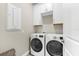 Laundry room featuring white cabinets and front loading washer and dryer units at 6791 Alstead Cir, Bradenton, FL 34202