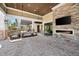 Inviting outdoor lounge with stone fireplace, comfortable seating, and pergola at 6791 Alstead Cir, Bradenton, FL 34202