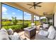 This screened patio offers a lake view and features comfortable outdoor seating and a fire pit at 6791 Alstead Cir, Bradenton, FL 34202