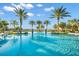A refreshing pool with water features and palm trees under a bright, sunny sky, perfect for relaxation at 6791 Alstead Cir, Bradenton, FL 34202