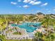 Aerial view of a resort-style pool with lounge chairs, tropical trees, and umbrellas at 6791 Alstead Cir, Bradenton, FL 34202