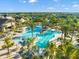 Beautiful aerial view of a community pool surrounded by palm trees, lounge chairs and manicured landscaping at 6791 Alstead Cir, Bradenton, FL 34202
