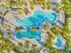 Aerial view of an elaborate resort-style swimming pool with palm trees and many lounge chairs at 6791 Alstead Cir, Bradenton, FL 34202