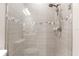 Modern tiled shower featuring glass door, rainfall showerhead, and tiled walls at 6791 Alstead Cir, Bradenton, FL 34202