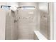 Modern walk-in shower featuring elegant tile work, a built-in bench, and natural light at 6791 Alstead Cir, Bradenton, FL 34202