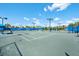 A tennis court with blue canopies for shade and lighting for playing at night at 6791 Alstead Cir, Bradenton, FL 34202
