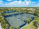 Aerial view of several community tennis courts surrounded by tropical landscaping and neighborhood homes at 6791 Alstead Cir, Bradenton, FL 34202
