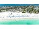 Aerial view of the beach with clear blue water, beach goers, and an access bridge in the distance at 6804 19Th W Ave, Bradenton, FL 34209