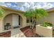 Inviting front entrance featuring decorative landscaping, a tiled walkway, and a partially open, arched front door at 6804 19Th W Ave, Bradenton, FL 34209