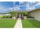 Inviting single-story home with verdant landscaping, a concrete walkway, and an arched doorway at 6804 19Th W Ave, Bradenton, FL 34209