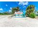 Welcome to Holmes Beach on Anna Maria Island sign, featuring palm trees and an Adirondack chair at 6804 19Th W Ave, Bradenton, FL 34209