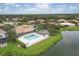 Aerial view of community pool, clubhouse, pond, and lush landscaping in a residential neighborhood at 7119 67Th E Ter, Bradenton, FL 34203