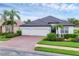 Charming one-story home with tile roof, three-car garage, palm trees, and brick-paved driveway at 7119 67Th E Ter, Bradenton, FL 34203