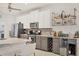 Modern kitchen with stainless steel appliances, stylish cabinetry, and a sleek wet bar area at 7119 67Th E Ter, Bradenton, FL 34203