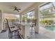 Stylish outdoor kitchen and bar area, featuring a marble counter, grill, and views of the pool at 7119 67Th E Ter, Bradenton, FL 34203
