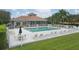 Community pool surrounded by lounge chairs, tables, and a white fence, with a clubhouse in the background at 7119 67Th E Ter, Bradenton, FL 34203