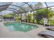 Relaxing pool and spa area with a screen enclosure, lounge chairs and a view of nature at 7119 67Th E Ter, Bradenton, FL 34203