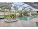 Beautiful screened pool and spa surrounded by lush landscaping offer a private backyard oasis at 7119 67Th E Ter, Bradenton, FL 34203