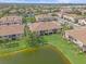 An aerial view of townhomes in a well-maintained community with lake, lush green grass, and mature trees at 7325 Skybird Rd # 399, Bradenton, FL 34209