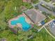Aerial view of the clover-shaped community pool and clubhouse surrounded by lush landscaping at 7325 Skybird Rd # 399, Bradenton, FL 34209