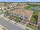 An aerial view of tan townhomes that feature two car garages, manicured lawns, and a pond at 7325 Skybird Rd # 399, Bradenton, FL 34209