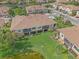Aerial view of townhomes with lush landscaping and a serene lake, showcasing a well-maintained community at 7325 Skybird Rd # 399, Bradenton, FL 34209