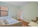 Bedroom featuring a trundle bed, light green walls, laminate wood floors, plus a window at 7325 Skybird Rd # 399, Bradenton, FL 34209