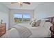 Bright bedroom with a large window offering views of a lake, plus a ceiling fan and a comfortable bed with many pillows at 7325 Skybird Rd # 399, Bradenton, FL 34209