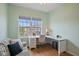 Bedroom with desk, chair, large window, daybed, and wood-look floors, offering a comfortable workspace and relaxing atmosphere at 7325 Skybird Rd # 399, Bradenton, FL 34209