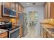 Well-equipped kitchen with stainless steel appliances, granite countertops, wooden cabinets, and an open view to the dining area at 7325 Skybird Rd # 399, Bradenton, FL 34209