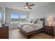 Cozy bedroom featuring a waterfront view, ceiling fan, comfortable bed, and warm bedside lighting at 7325 Skybird Rd # 399, Bradenton, FL 34209