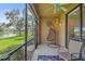 Relaxing screened patio with hanging chair, ceiling fan, and view of the lush landscaping and serene lake at 7325 Skybird Rd # 399, Bradenton, FL 34209