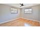 Bedroom with hardwood floors, ceiling fan, and windows with wood blinds at 7355 Cass Cir, Sarasota, FL 34231