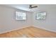 Bedroom with hardwood floors, two windows providing natural light, and a ceiling fan at 7355 Cass Cir, Sarasota, FL 34231
