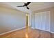 Bright bedroom features hardwood floors, ceiling fan, and closet with louvered doors at 7355 Cass Cir, Sarasota, FL 34231