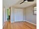 Clean bedroom features hardwood floors, large closet with louvered doors, and a ceiling fan at 7355 Cass Cir, Sarasota, FL 34231