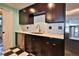 Well-equipped kitchen with dark wood cabinets, stainless steel appliances, and eye-catching black and white flooring at 7355 Cass Cir, Sarasota, FL 34231