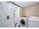 Laundry room boasts washer, dryer, and barn door to bathroom at 7355 Cass Cir, Sarasota, FL 34231