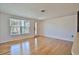 Bright living room with hardwood floors, a large window, and a white door at 7355 Cass Cir, Sarasota, FL 34231