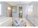 Bathroom offering a tub, vanity with cabinets, and glass-enclosed shower with beige tiles at 7542 Windy Hill Cv, Bradenton, FL 34202