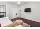 Bedroom featuring hardwood floors, a ceiling fan, and a TV on the wall at 7542 Windy Hill Cv, Bradenton, FL 34202