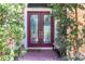 Elegant double front doors with glass inserts, framed by lush greenery at 7542 Windy Hill Cv, Bradenton, FL 34202