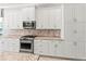 Gourmet kitchen features white cabinetry, stainless steel appliances, and granite countertops at 7542 Windy Hill Cv, Bradenton, FL 34202