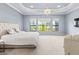 Spacious main bedroom featuring golf course views, a chandelier, and ample natural light at 7542 Windy Hill Cv, Bradenton, FL 34202