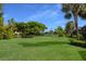 Beautiful backyard with lush green grass, mature trees, and tranquil water view at 8291 Varenna Dr, Sarasota, FL 34231