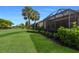 Expansive backyard showcasing vibrant green grass, lush landscaping, and a glimpse of the screened-in patio at 8291 Varenna Dr, Sarasota, FL 34231