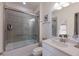 Bathroom featuring a bathtub with glass doors, a single sink vanity, and a decorative mirror at 8291 Varenna Dr, Sarasota, FL 34231