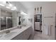 Bathroom featuring dual sinks, a large mirror, a glass-enclosed shower, and access to a closet at 8291 Varenna Dr, Sarasota, FL 34231