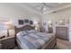 Serene primary bedroom featuring a tray ceiling, soft lighting, and a glimpse into the ensuite bathroom at 8291 Varenna Dr, Sarasota, FL 34231