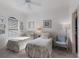 Bright bedroom featuring two twin beds with coastal decor, a ceiling fan, and a window for natural light at 8291 Varenna Dr, Sarasota, FL 34231